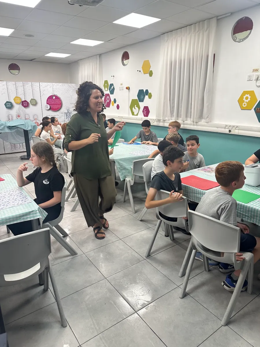 ילדים בסדנה סביב שולחנות העבודה