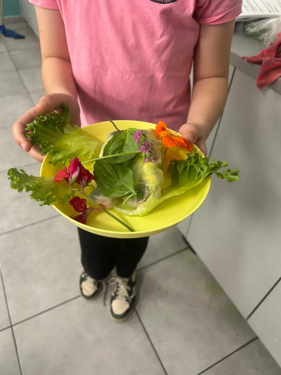 ילדה מחזיקה צלחת סלט צבעונית שהכינה