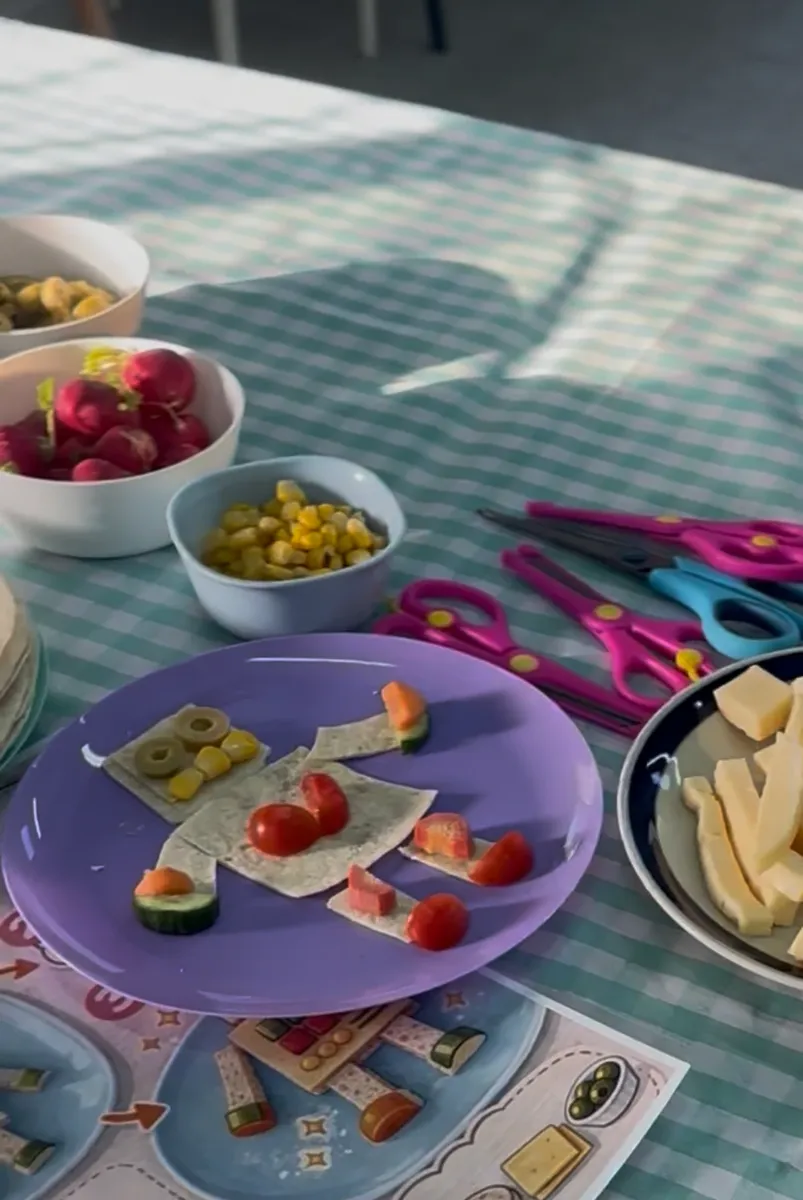 רובוט מטורטיה וירקות על צלחת, ליד כרטיס ההוראות